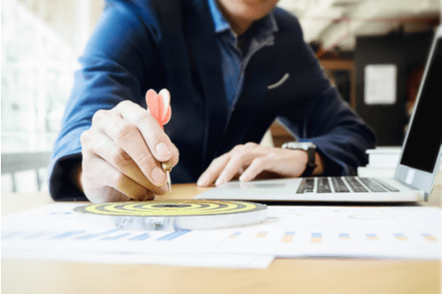 business man holding dart