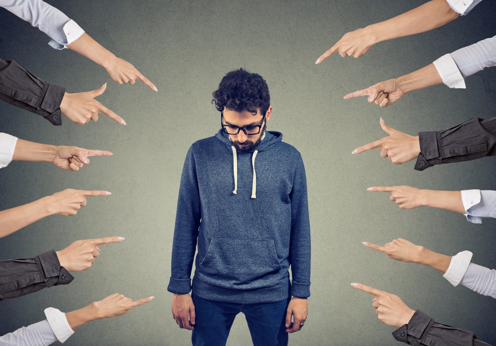 fingers pointing at male in sweatshirt