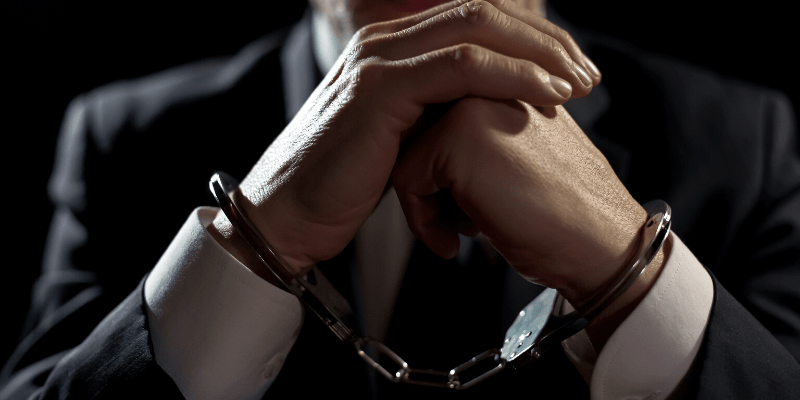 man in suit handcuffed