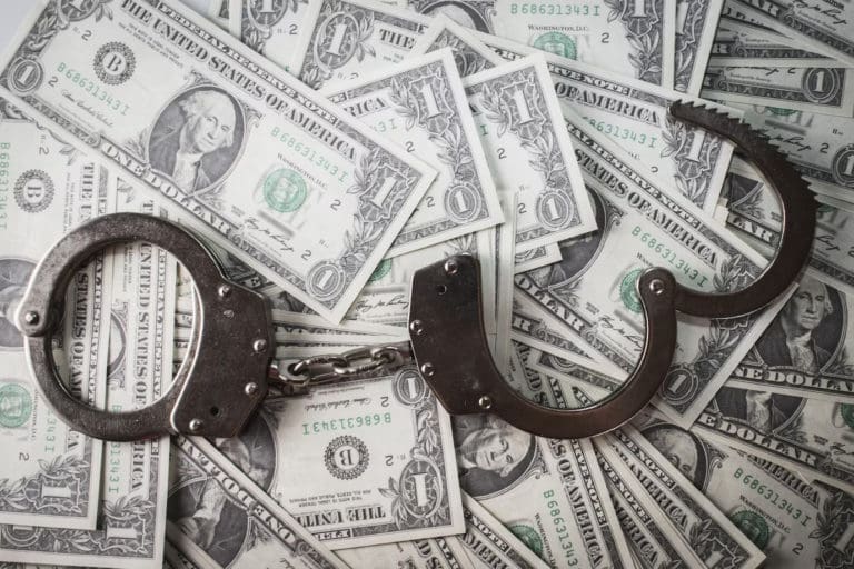 handcuffs on a pile of money.