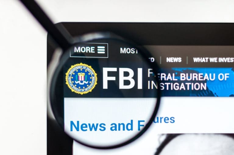 The fbi website is shown through a magnifying glass.