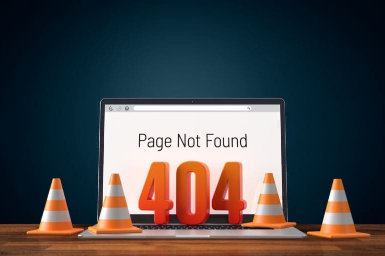Page not found on a laptop with orange cones.