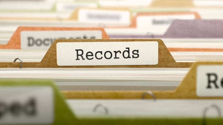 A stack of files with the word records on them.