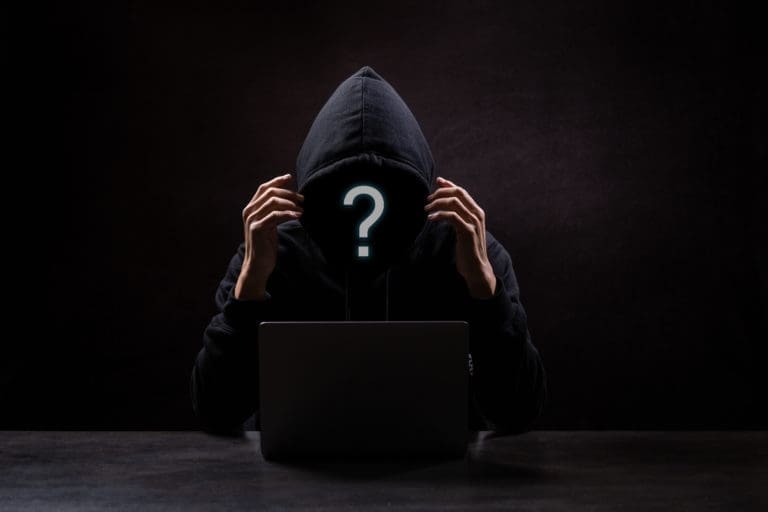 A man in a black hoodie with a question mark on his face.
