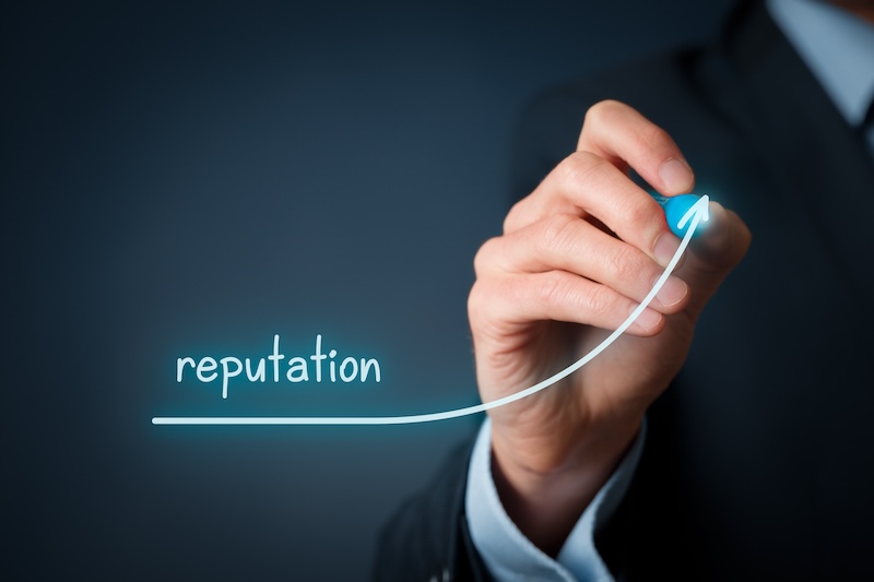 A person in a suit draws an upward-curving arrow with the word “reputation,” symbolizing growth and effective ORM dos and don'ts, on a dark background.